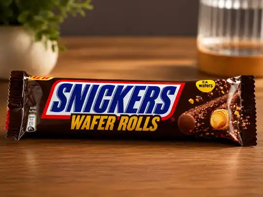 Snickers Wafer Rolls Packung mit zwei Waffelrollen auf einem Holztisch